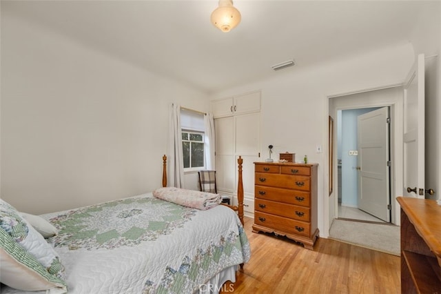 bedroom featuring visible vents, a closet, and light wood finished floors