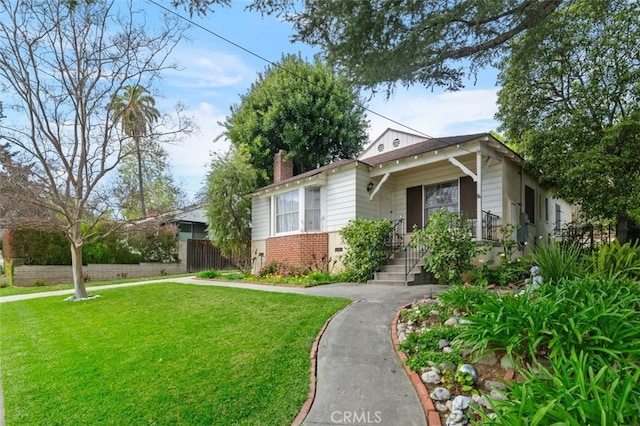 view of front of property featuring a front lawn, fence, and a chimney