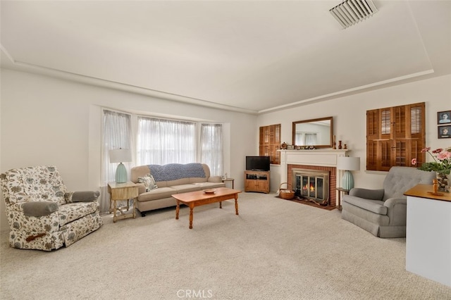 living room featuring a brick fireplace, carpet flooring, and visible vents