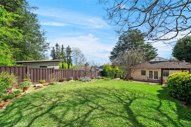 view of yard with french doors and a fenced backyard