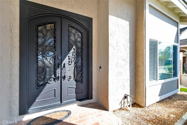 doorway to property featuring stucco siding