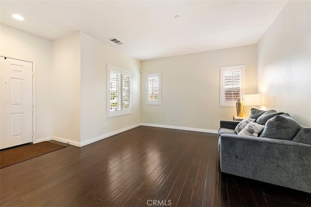 living area with visible vents, dark wood-type flooring, and baseboards