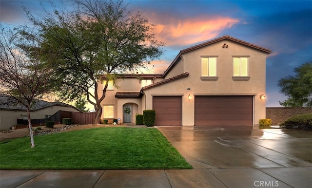 mediterranean / spanish-style house featuring a front yard, fence, stucco siding, concrete driveway, and a tile roof