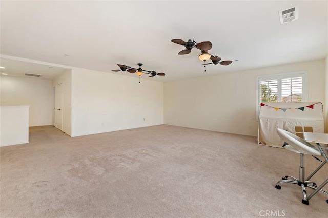 spare room featuring light carpet, visible vents, and ceiling fan