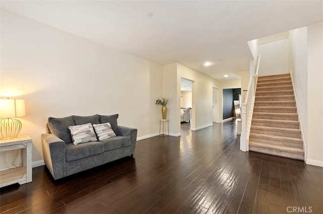 sitting room with stairway, baseboards, and dark wood-style floors