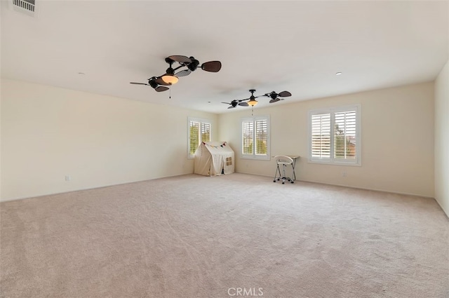 spare room featuring carpet flooring, visible vents, and ceiling fan