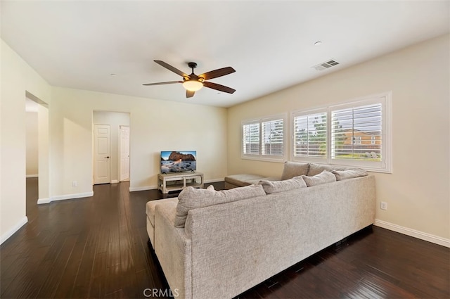 living area featuring visible vents, baseboards, ceiling fan, and dark wood-style flooring