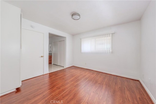 unfurnished room featuring light wood-style floors and baseboards