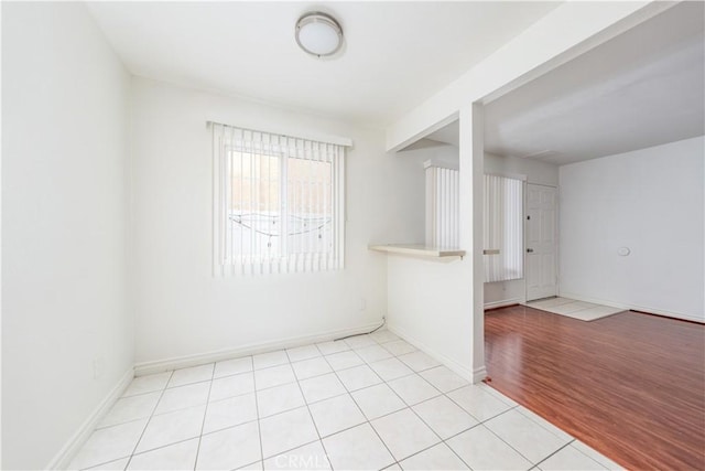 empty room featuring light tile patterned floors and baseboards