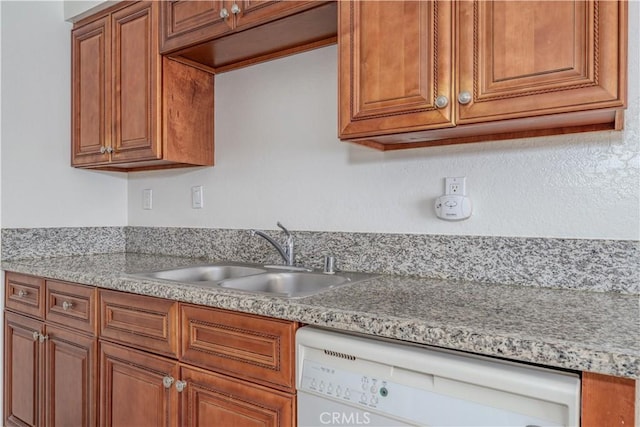 kitchen with a sink, dishwasher, brown cabinetry, and light countertops