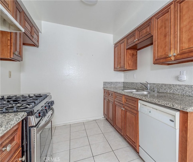 kitchen featuring brown cabinetry, white dishwasher, a sink, under cabinet range hood, and gas range