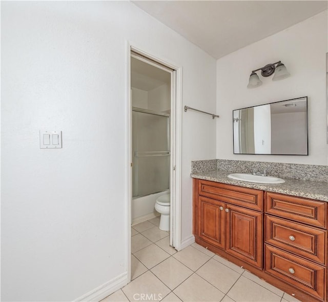 bathroom featuring vanity, tile patterned floors, toilet, and baseboards