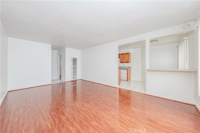 spare room with light wood-type flooring and baseboards