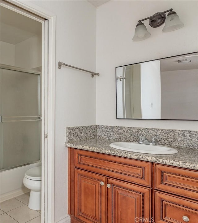 bathroom featuring tile patterned floors, bath / shower combo with glass door, toilet, and vanity