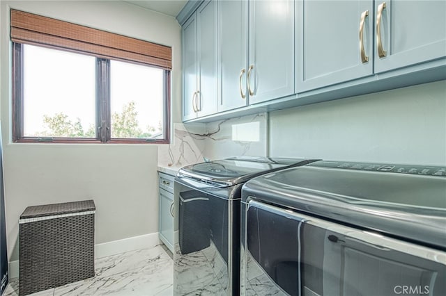 clothes washing area with cabinet space, washer and dryer, marble finish floor, and baseboards