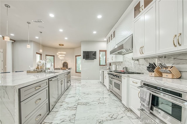 kitchen featuring visible vents, marble finish floor, a sink, stainless steel appliances, and wall chimney range hood