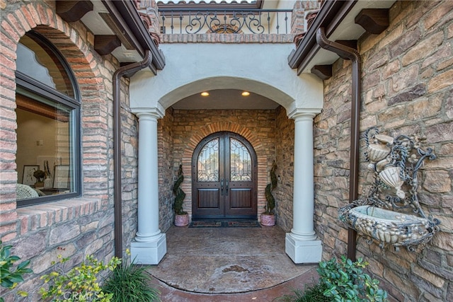 property entrance featuring french doors and stone siding