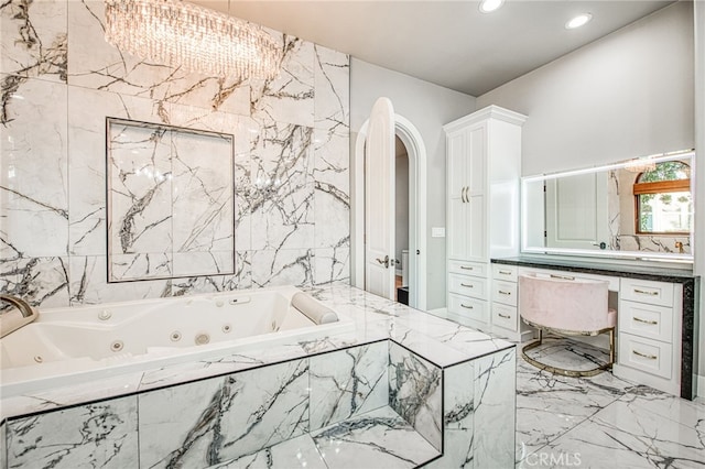 bathroom featuring recessed lighting, a whirlpool tub, marble finish floor, and vanity