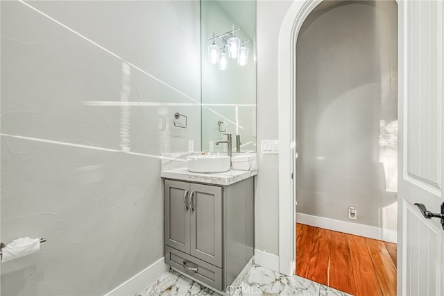 bathroom featuring baseboards, marble finish floor, and vanity