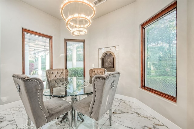 dining room featuring a chandelier, visible vents, marble finish floor, and baseboards