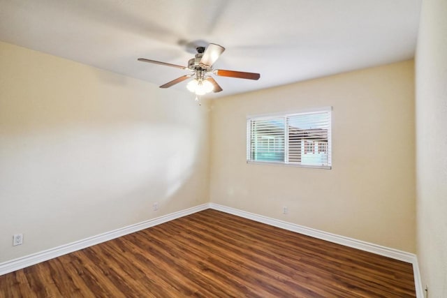 unfurnished room with baseboards, wood finished floors, and a ceiling fan