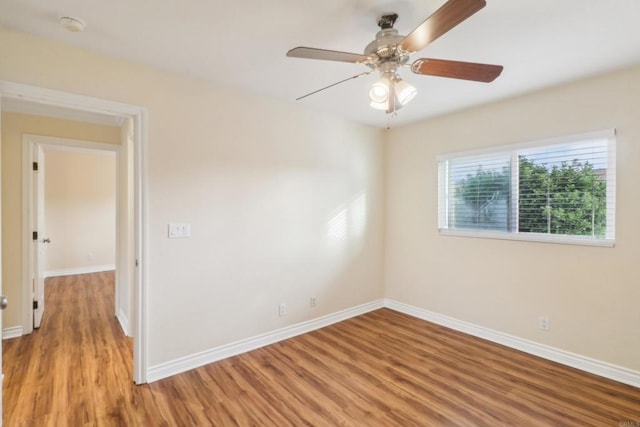 empty room featuring light wood-style flooring, a ceiling fan, and baseboards