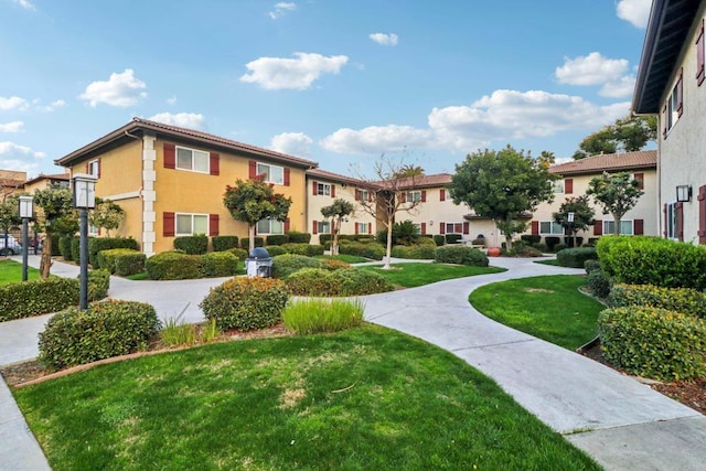 view of property's community with a residential view and a lawn