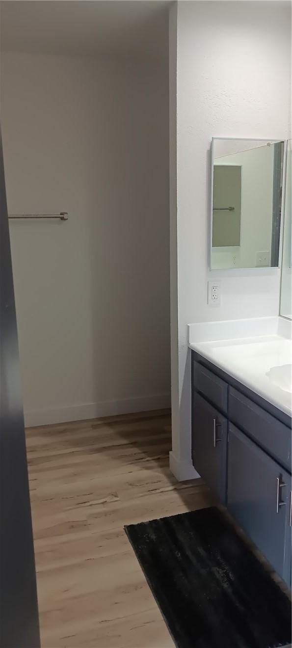 bathroom featuring vanity, baseboards, and wood finished floors