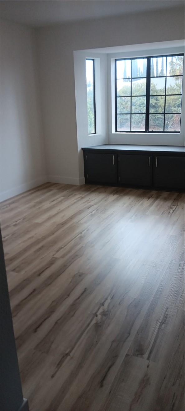 spare room featuring baseboards and wood finished floors