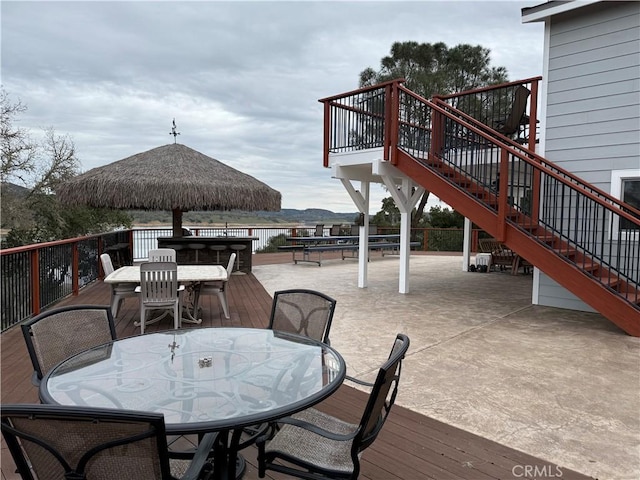 deck with outdoor dining space and stairs