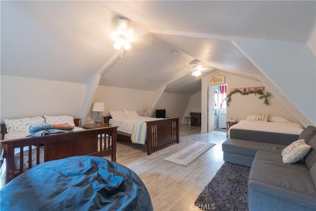 bedroom with light wood-type flooring and lofted ceiling