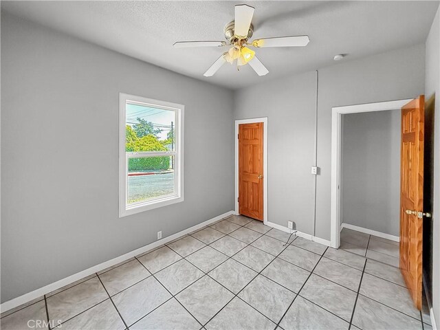 1685 Washington Ave, Oroville, CA 95966 - unfurnished bedroom featuring light tile patterned floors, baseboards, and a ceiling fan
