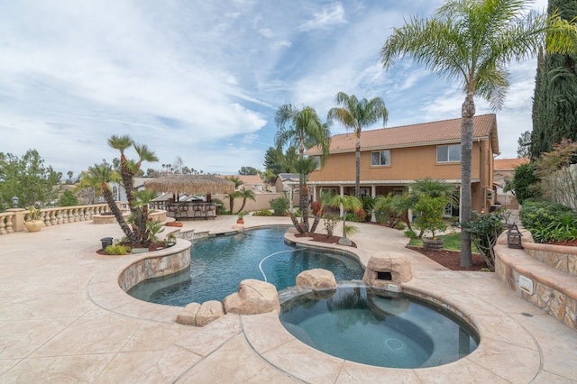 view of pool featuring a patio, fence, and a pool with connected hot tub