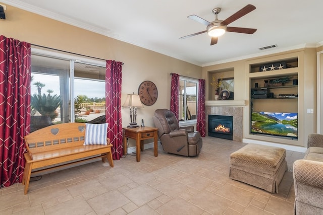 living area with crown molding, visible vents, and ceiling fan