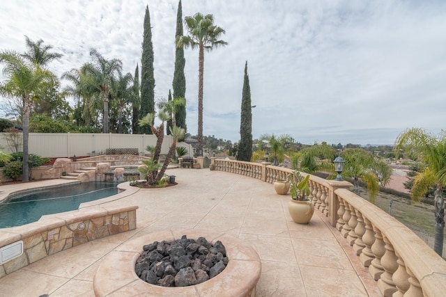 view of patio / terrace featuring a fenced backyard, a fenced in pool, and a fire pit