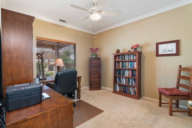 office featuring a ceiling fan, visible vents, baseboards, crown molding, and light colored carpet