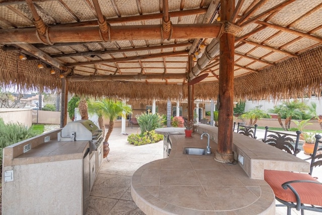 view of patio / terrace with grilling area, an outdoor kitchen, and a sink