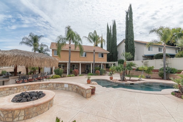 outdoor pool featuring a patio, a fire pit, and fence