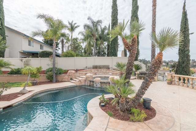 view of swimming pool with a pool with connected hot tub, a fenced backyard, and a patio area