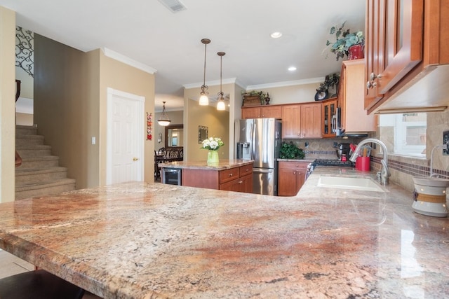 kitchen featuring a center island, light stone counters, decorative backsplash, stainless steel appliances, and a sink