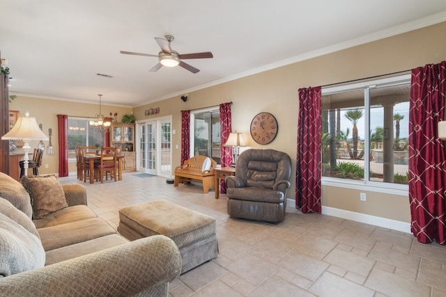 living area featuring stone tile flooring, ceiling fan with notable chandelier, baseboards, and ornamental molding