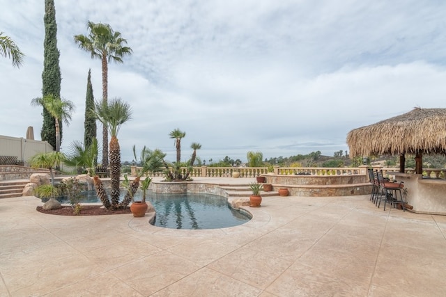 pool featuring a patio area, outdoor dry bar, and fence