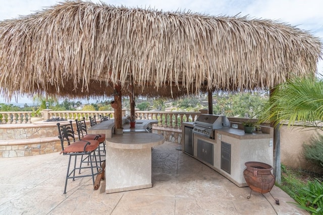 view of patio / terrace with area for grilling, outdoor dry bar, and a grill