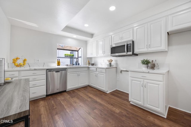 kitchen featuring a sink, recessed lighting, appliances with stainless steel finishes, white cabinets, and dark wood-style flooring