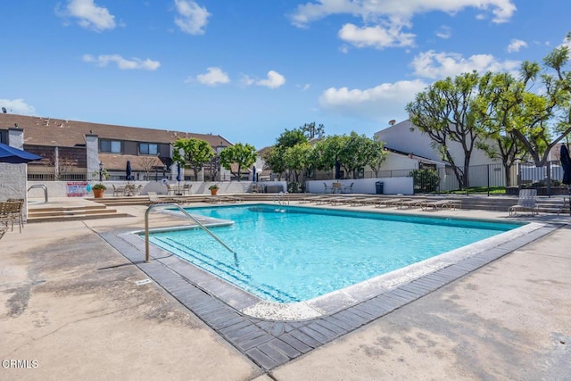 community pool featuring a patio and fence