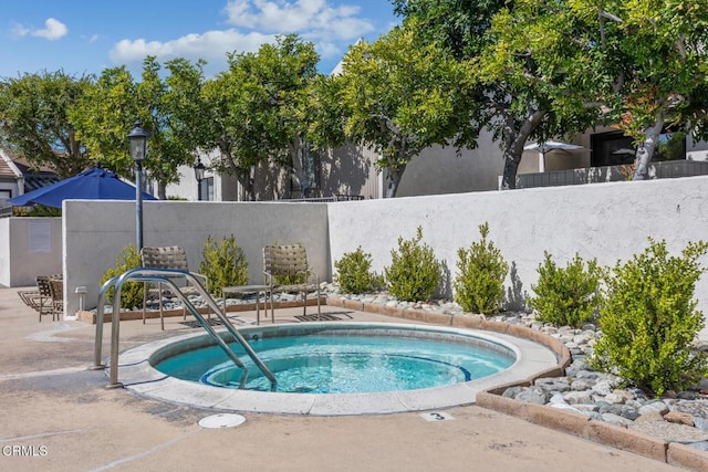 view of pool featuring a patio, a community hot tub, and fence