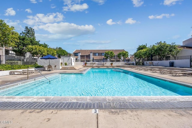 pool featuring fence and a patio area