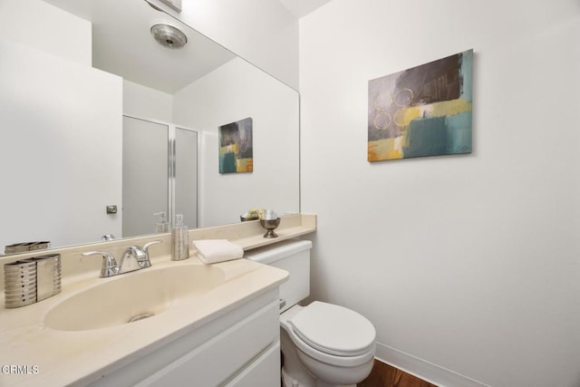 full bathroom with a shower stall, toilet, vanity, and baseboards