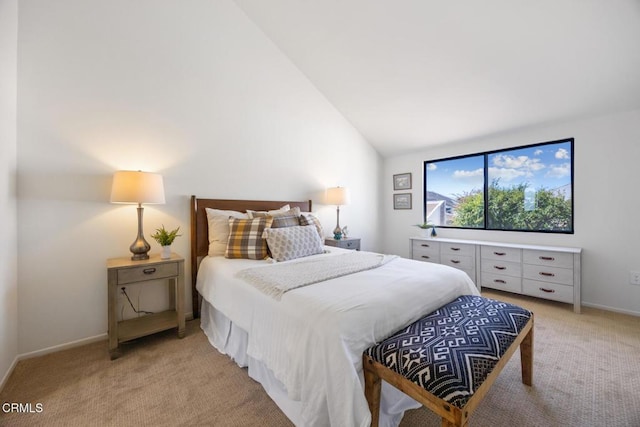 bedroom featuring light colored carpet, baseboards, and vaulted ceiling