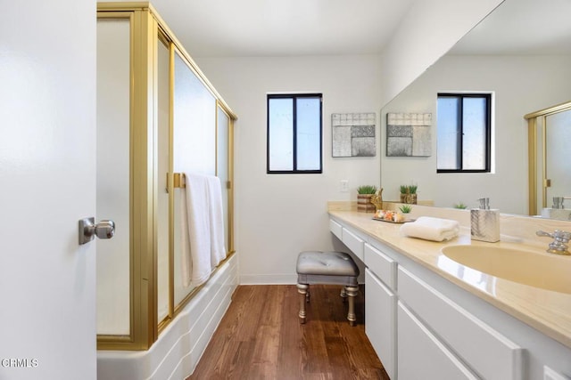 full bathroom featuring enclosed tub / shower combo, a healthy amount of sunlight, wood finished floors, and vanity